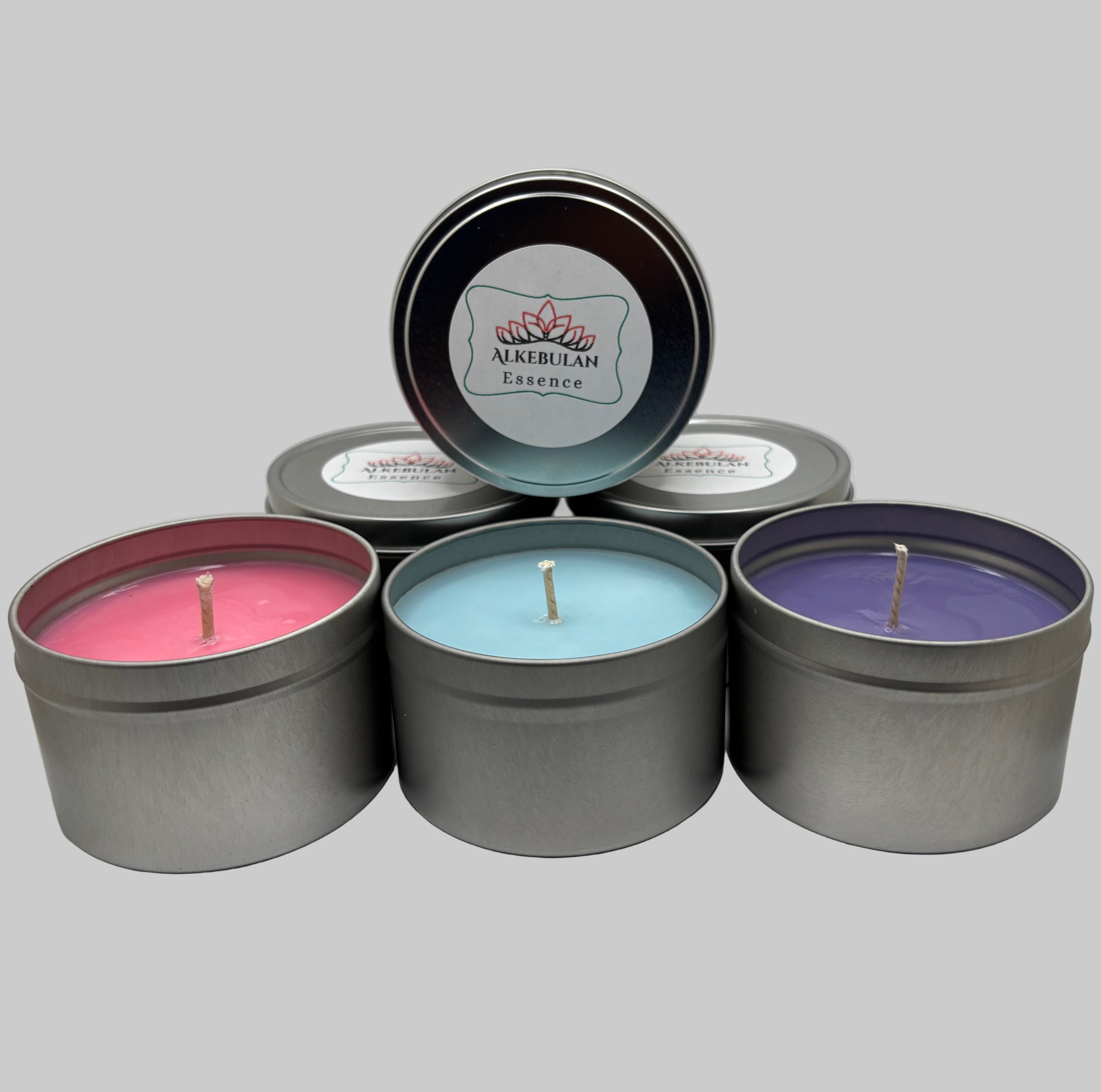 Five tin candles with different colored waxes and a visible brand logo on a white background.